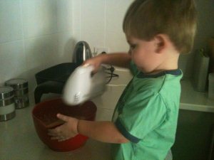 Hugo using the electric beater to mix pikelet mixture