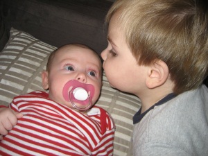 Hugo Lattimore kissing 2 month old Evie Lattimore on the forehead